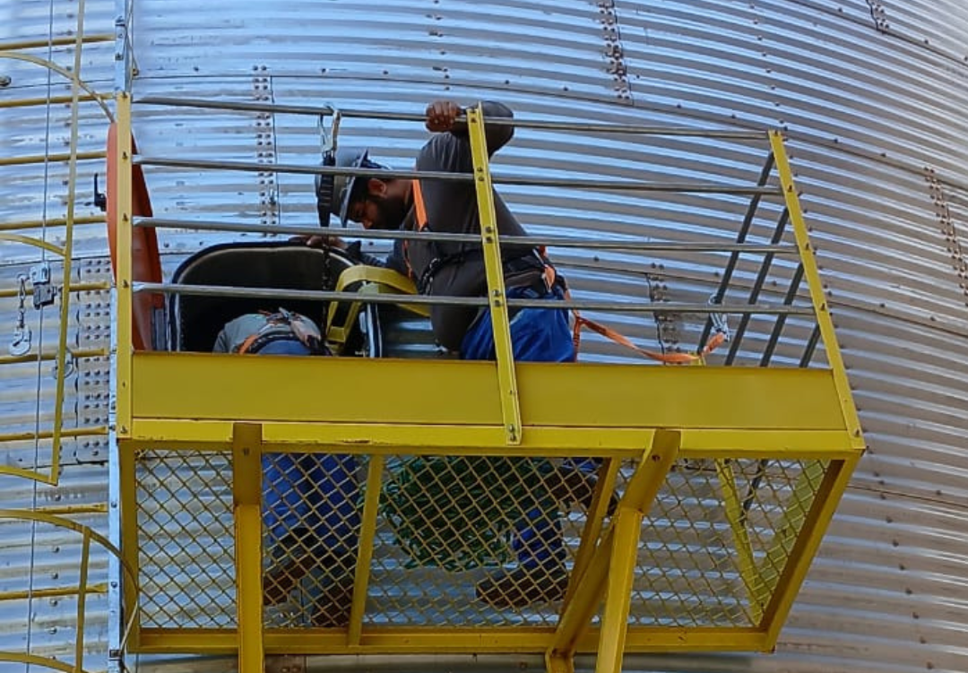 Equipe de instaladores em campo, com equipamentos de segurança.